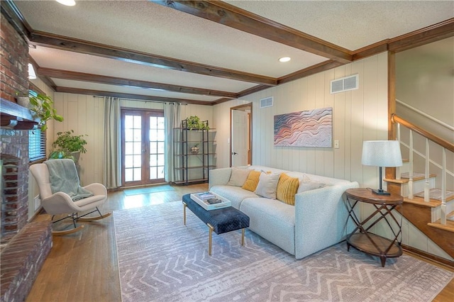 10312 Lamar Ave, Overland Park, KS 66207 - living room featuring wood finished floors, stairway, beam ceiling, a textured ceiling, and crown molding