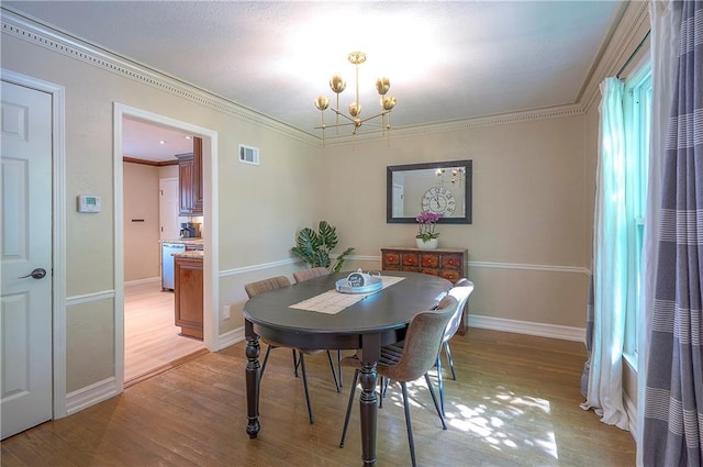 10312 Lamar Ave, Overland Park, KS 66207 - dining area with a chandelier, light wood finished floors, baseboards, and crown molding