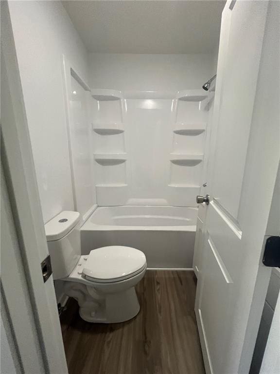 bathroom featuring wood finished floors, toilet, and shower / bathtub combination