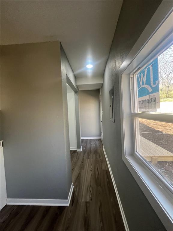 hallway with baseboards and dark wood-type flooring