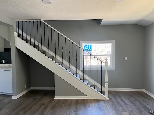 stairway with baseboards, lofted ceiling, and wood finished floors
