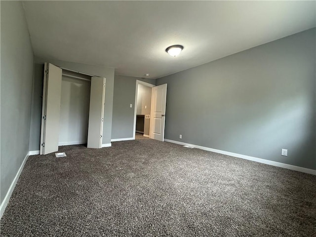 unfurnished bedroom featuring baseboards, a closet, and carpet
