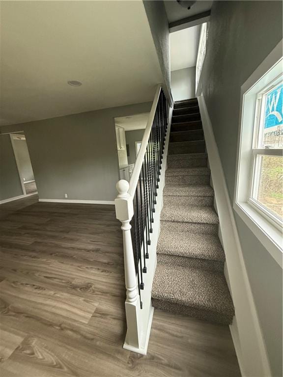 stairway featuring baseboards and wood finished floors