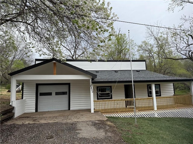 view of front of house with roof with shingles, aphalt driveway, a front yard, covered porch, and a garage