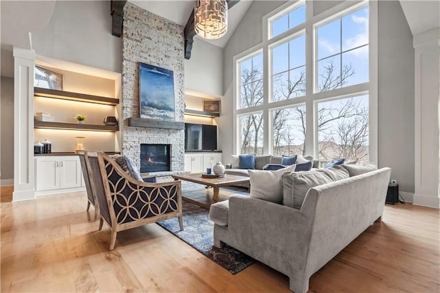living room with high vaulted ceiling, a fireplace, hardwood / wood-style floors, and baseboards