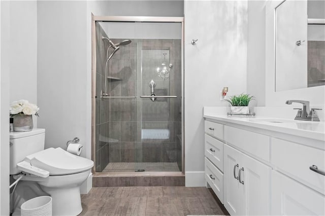 bathroom with toilet, a shower stall, and vanity