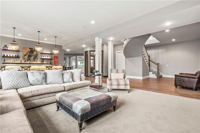 living room featuring recessed lighting, a dry bar, baseboards, stairs, and wood finished floors