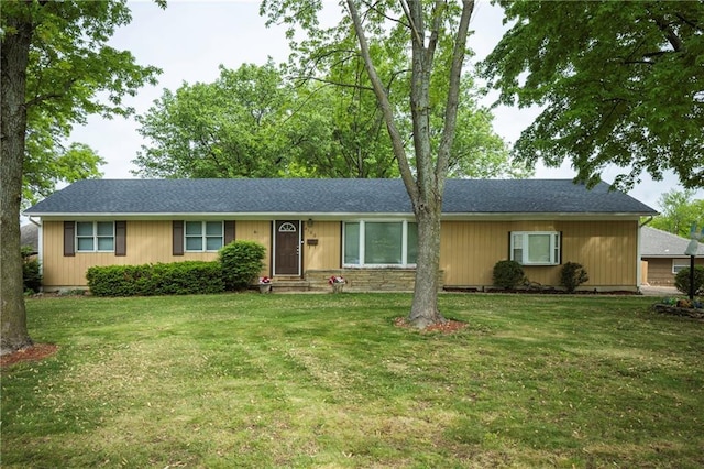 ranch-style home with roof with shingles and a front yard