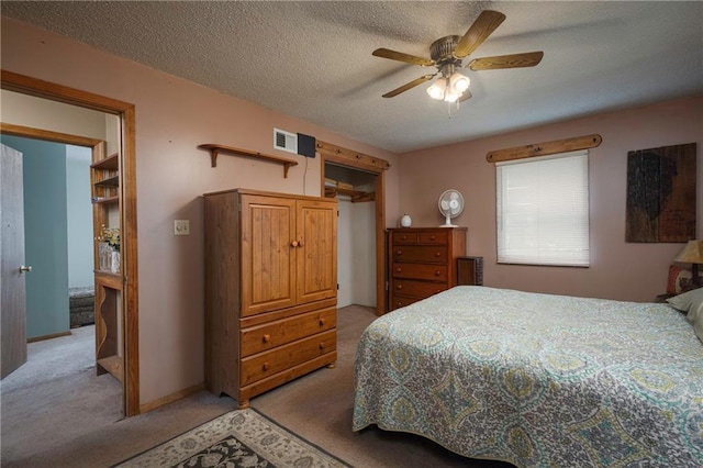bedroom featuring ceiling fan, light colored carpet, a textured ceiling, and visible vents