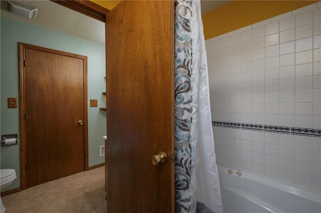 bathroom featuring visible vents, a textured ceiling, shower / bath combo with shower curtain, and toilet