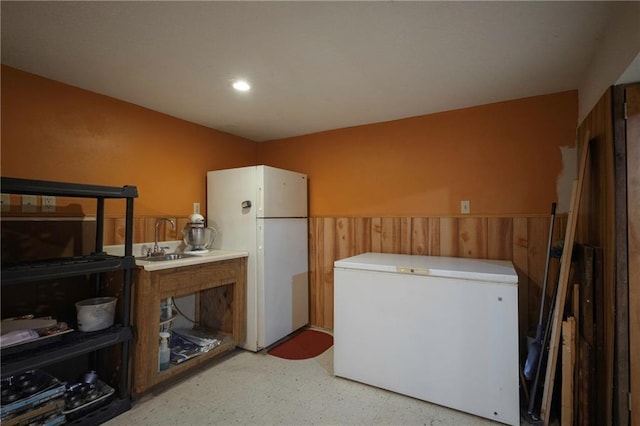 clothes washing area with a sink and light floors