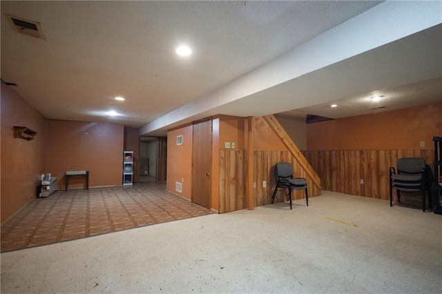 finished below grade area featuring stairway, recessed lighting, and visible vents