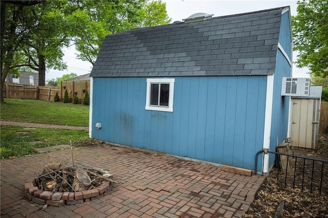 view of shed with a fenced backyard and an outdoor fire pit