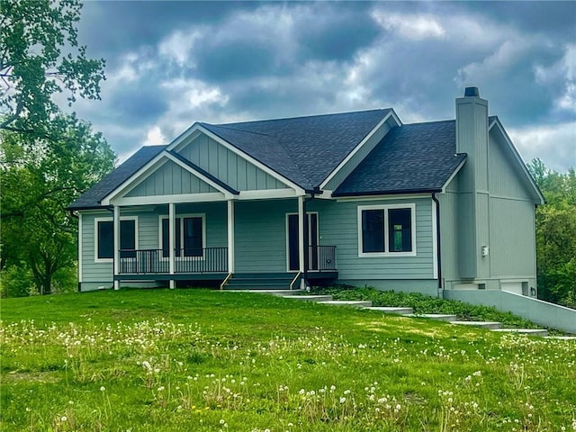 view of front of house with a front yard, a chimney, and roof with shingles