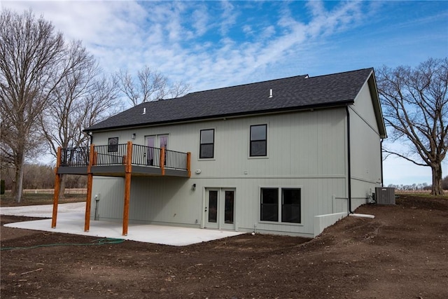 rear view of property featuring a shingled roof, a patio area, central air condition unit, and french doors