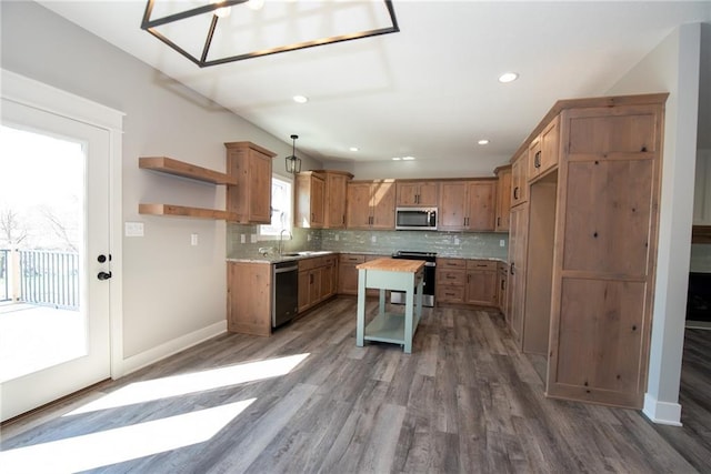 kitchen featuring backsplash, appliances with stainless steel finishes, open shelves, wood finished floors, and light countertops