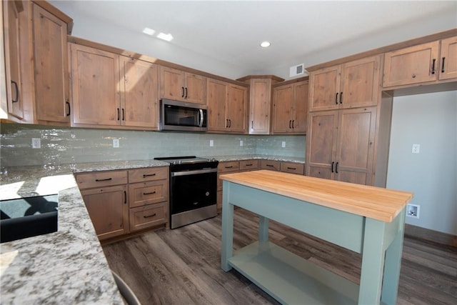 kitchen featuring decorative backsplash, stainless steel appliances, dark wood-style flooring, and visible vents