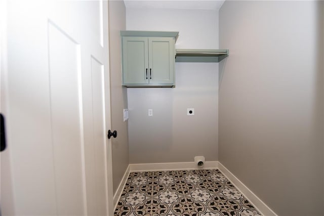 laundry room featuring electric dryer hookup, cabinet space, and baseboards