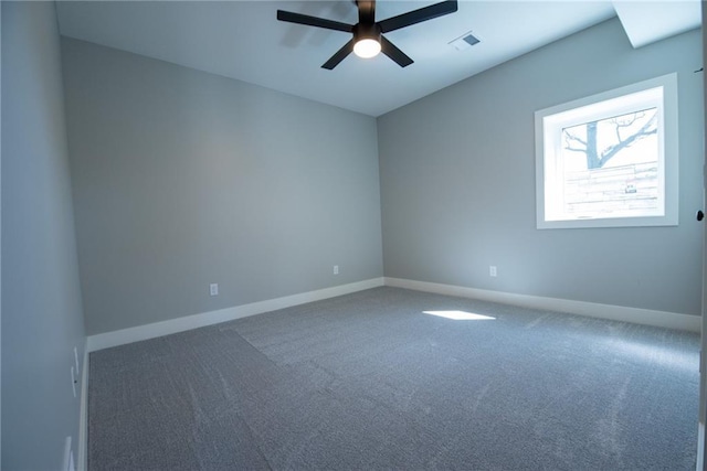 spare room with carpet flooring, ceiling fan, visible vents, and baseboards