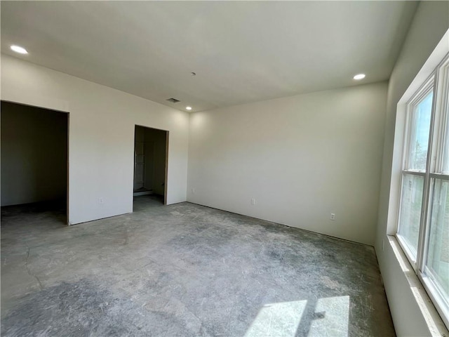 unfurnished bedroom with visible vents, multiple windows, and recessed lighting