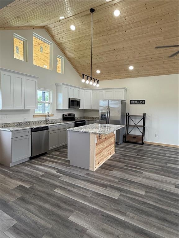 906 Park St, Cherryvale, KS 67335 - kitchen with appliances with stainless steel finishes, high vaulted ceiling, wood ceiling, a kitchen island, and light stone counters