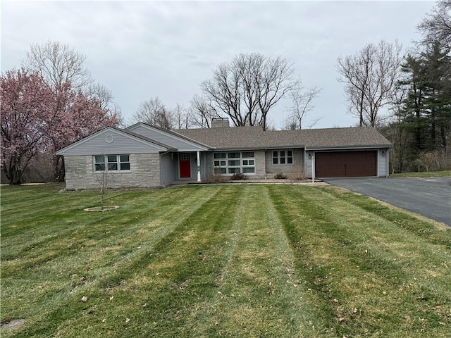 1020 Francis St, Lexington, MO 64067 - ranch-style house featuring a chimney, aphalt driveway, a front lawn, stone siding, and a garage