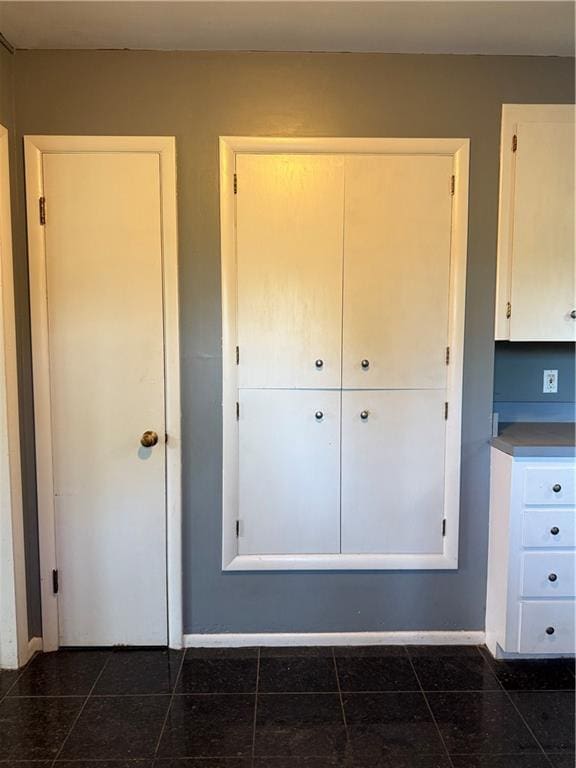 1020 Francis St, Lexington, MO 64067 - unfurnished bedroom featuring a closet, dark tile patterned floors, and baseboards