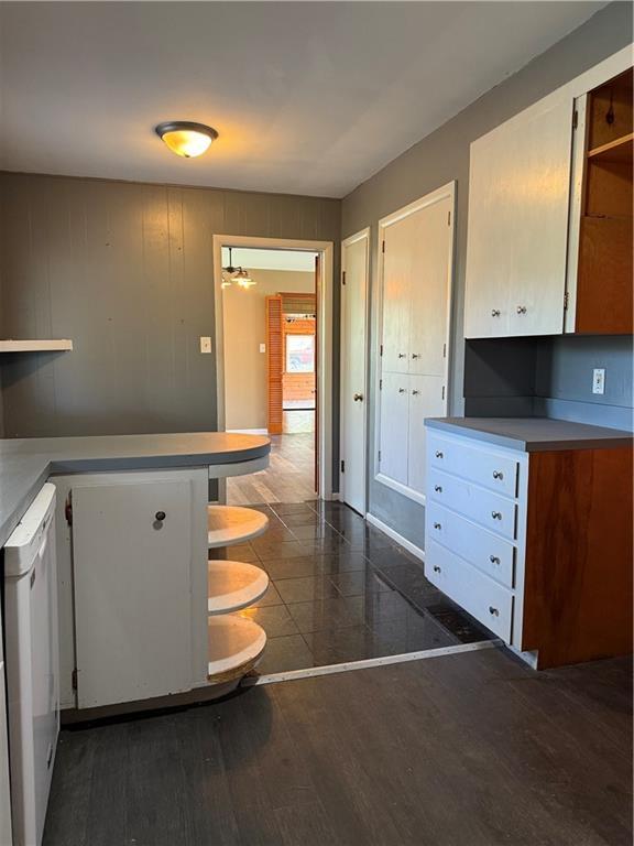 1020 Francis St, Lexington, MO 64067 - kitchen featuring open shelves, light countertops, dishwasher, and dark wood-style flooring