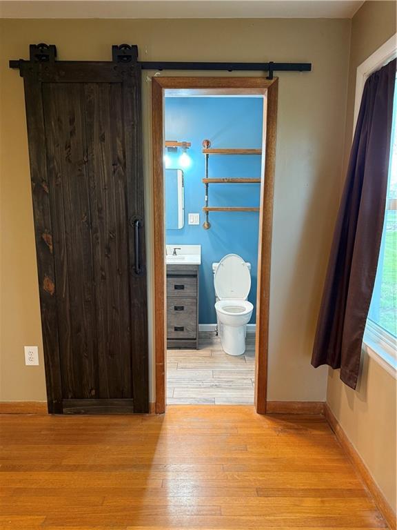 1020 Francis St, Lexington, MO 64067 - bathroom with toilet, vanity, wood finished floors, and baseboards