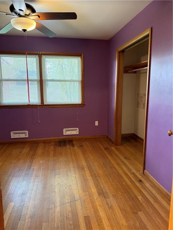 1020 Francis St, Lexington, MO 64067 - unfurnished bedroom with a ceiling fan, baseboards, a closet, and light wood-type flooring
