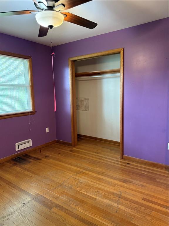 1020 Francis St, Lexington, MO 64067 - unfurnished bedroom featuring ceiling fan, baseboards, light wood-style floors, and a closet