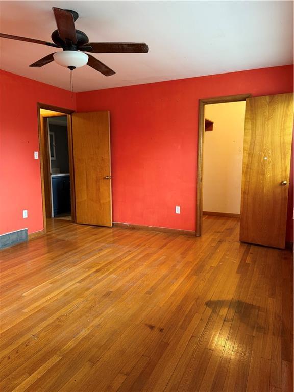 1020 Francis St, Lexington, MO 64067 - unfurnished bedroom with wood-type flooring, baseboards, and ceiling fan