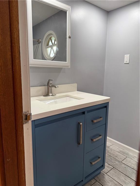 1020 Francis St, Lexington, MO 64067 - bathroom with wood finished floors, vanity, and baseboards