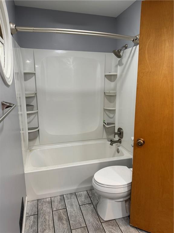 1020 Francis St, Lexington, MO 64067 - bathroom featuring toilet, wood finish floors, and shower / bath combination