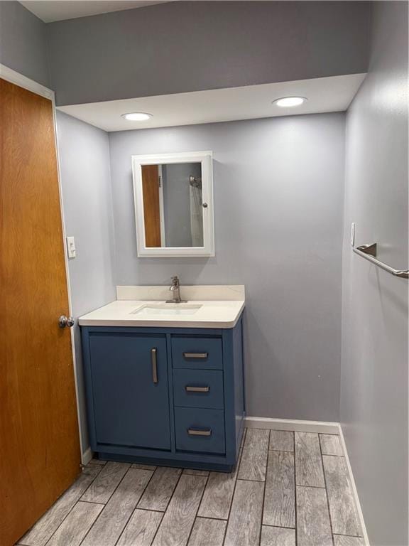 1020 Francis St, Lexington, MO 64067 - bathroom with baseboards, wood tiled floor, recessed lighting, and vanity
