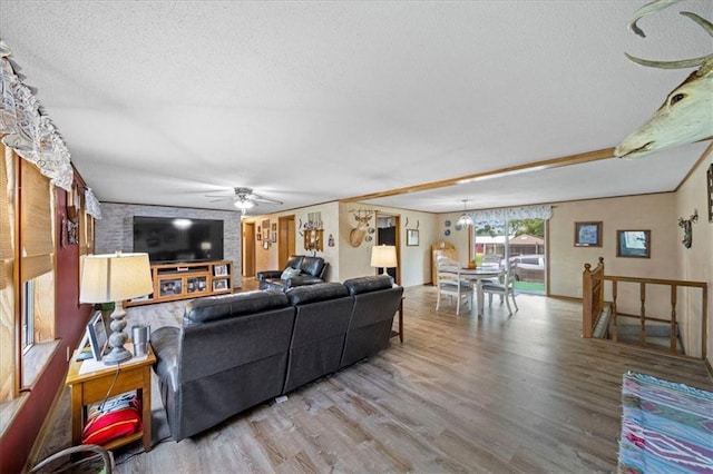 living room with wood finished floors, ceiling fan, and a textured ceiling