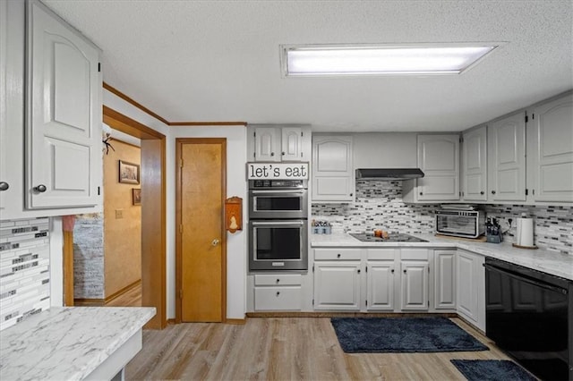 kitchen with black electric cooktop, light wood-style flooring, light countertops, and stainless steel double oven