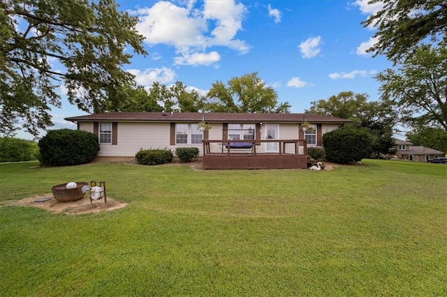 rear view of house with an outdoor fire pit and a lawn