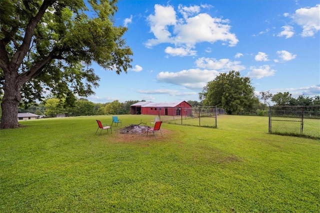 view of yard with fence, a pole building, and an outdoor structure