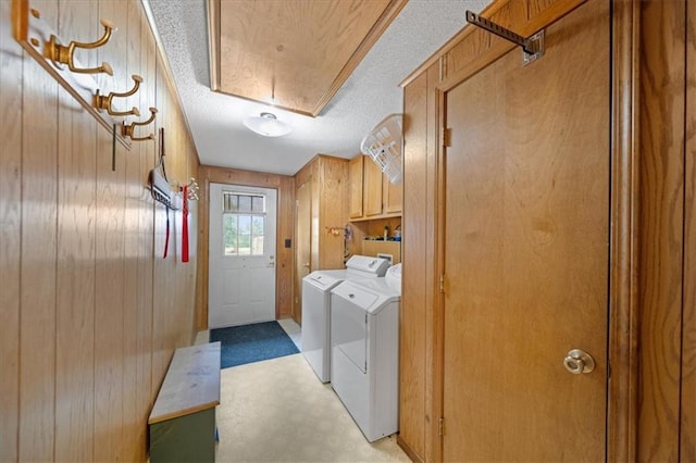 laundry area with attic access, wood walls, and cabinet space
