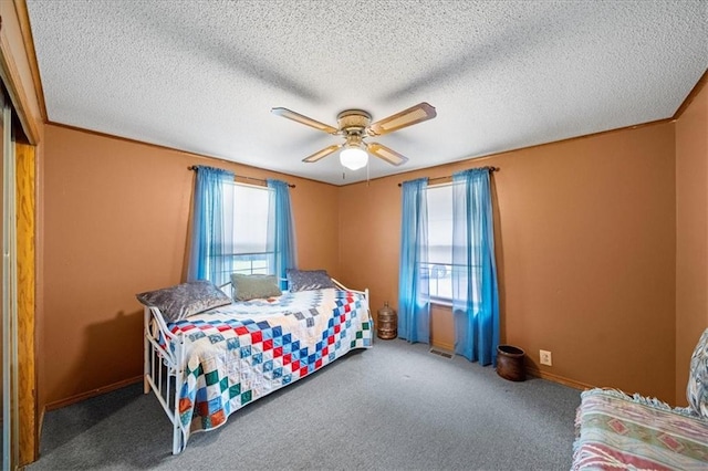 bedroom with baseboards, ceiling fan, carpet floors, and a textured ceiling