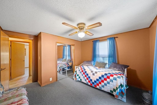 carpeted bedroom featuring a ceiling fan, a closet, baseboards, and a textured ceiling