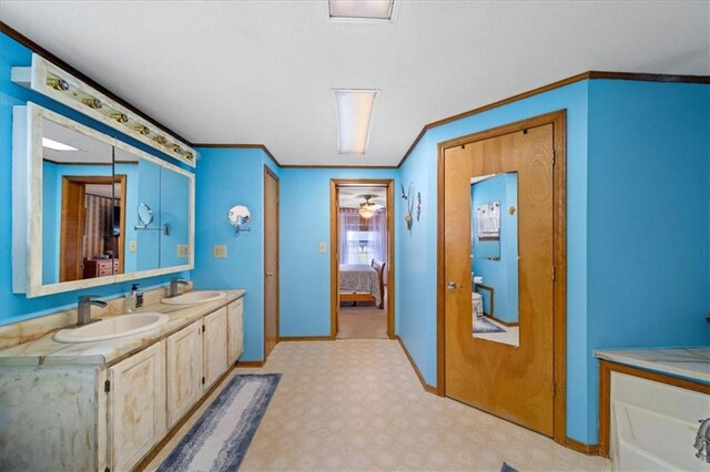 ensuite bathroom with ensuite bath, a sink, double vanity, and crown molding
