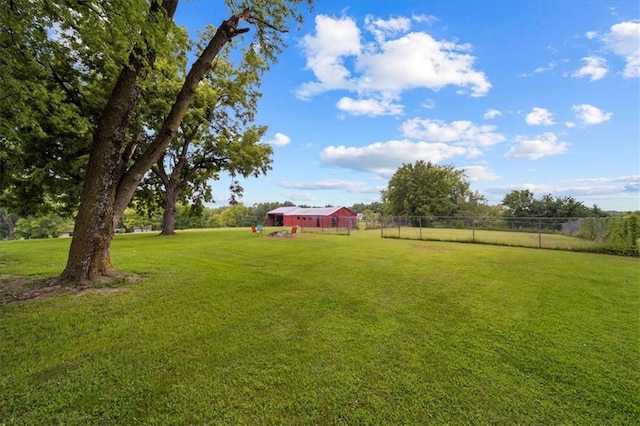 view of yard with fence and a rural view