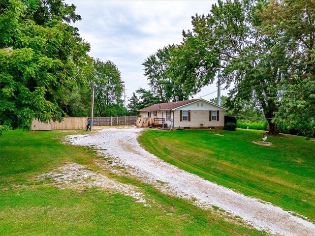 view of yard featuring driveway and fence