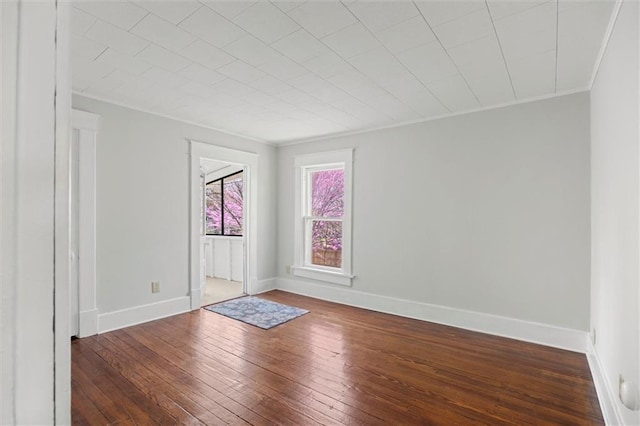 unfurnished room featuring crown molding, baseboards, and hardwood / wood-style flooring