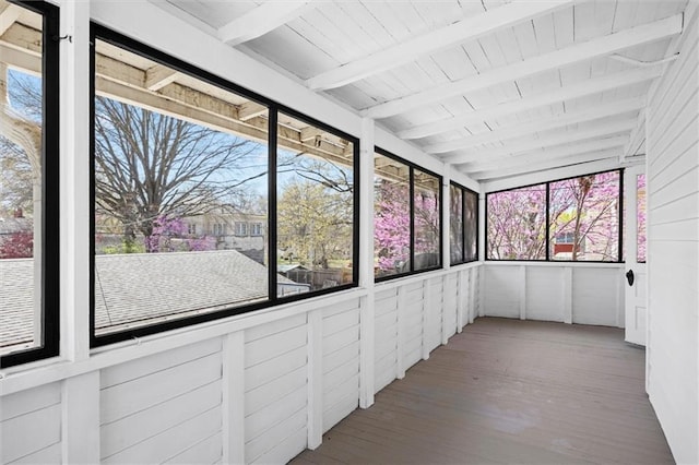 unfurnished sunroom with beamed ceiling