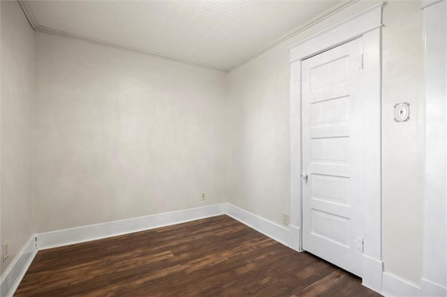 unfurnished room with dark wood-style floors, baseboards, and crown molding