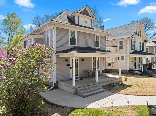 american foursquare style home with french doors and covered porch