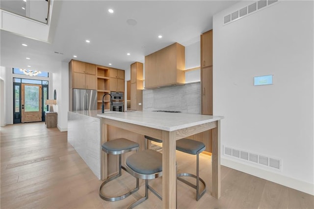 kitchen with tasteful backsplash, open shelves, appliances with stainless steel finishes, light wood finished floors, and visible vents